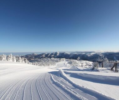Groomed ski slope and mountain panorama with clear blue sky near Shiga Ichii Hotel in Nagano