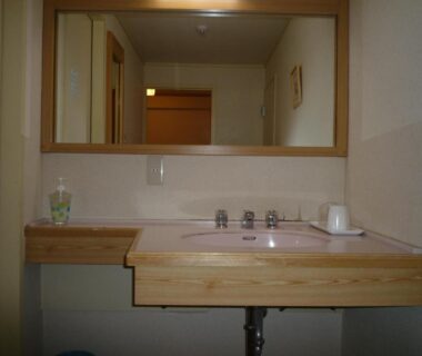 Sink and mirror with wooden counter in Shiga Kogen Hotel bathroom, Nagano