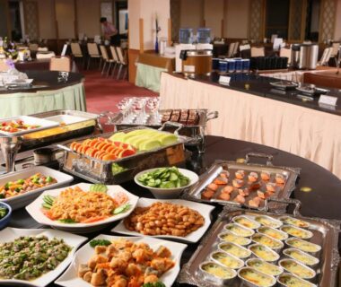 Buffet spread of hot dishes and salads on serving counters in the dining hall at Shiga Palace Hotel, Nagano