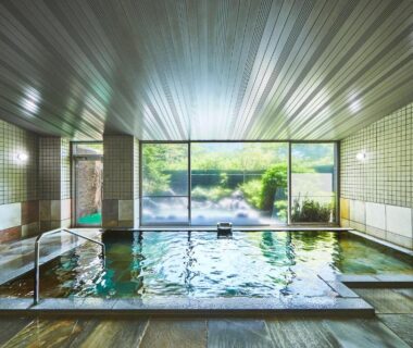 Indoor onsen bath with tiled walls and garden view at Shiki Resort Hakone Style in Kanagawa, Kanto, Japan