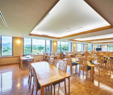 Spacious dining area with wooden tables and large windows overlooking green landscape at Shiki Resort Hakone Style Kanagawa