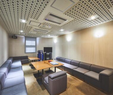 Karaoke room with wraparound leather sofas, low table and TV karaoke system at Shiki Resort Hakone Style, Kanagawa