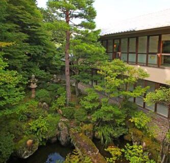 Central courtyard garden with pond, stone lantern and trees at Shiki Resort Hida Takayamaso in Gifu