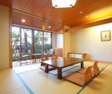 Traditional tatami room with low wooden table, zabuton cushions and garden-facing windows at Shiki Resort Hida Takayamaso, Gifu
