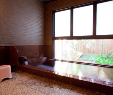 Indoor wooden onsen bath with washing area and garden view at Shiki Resort Kyoto Kamogawaso, Kyoto
