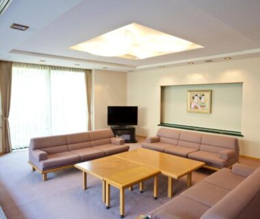 Spacious lounge with sofas, low wooden tables, TV and skylight at Shiki Resort Kyoto Kamogawaso in Kyoto
