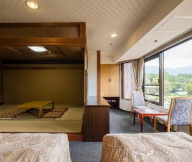 Tatami space with low table, twin western beds and window seating overlooking wooded hills