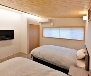 Twin bedroom with wooden ceiling, twin beds and shoji-style window at Shikinosato Hanamura, Kumamoto