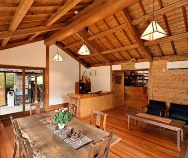 Spacious wooden dining area with high beams at Shikinosato Hanamura, Kumamoto, Kyūshū