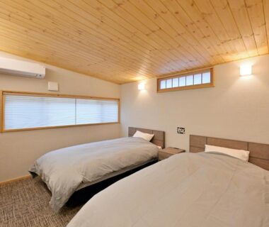 Twin beds in warm wood-ceiling room at Shikinosato Hanamura, Kumamoto, Kyushu