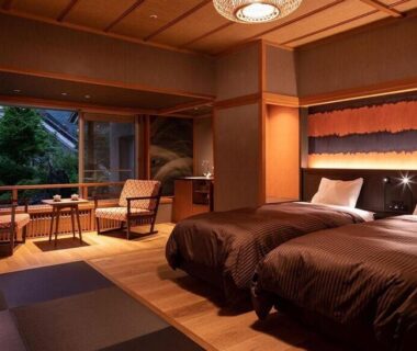 Tatami room with twin beds, seating area and garden view at Shima Tamura in Gunma Kanto