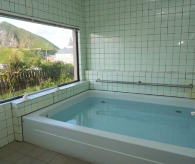 Indoor tiled bath with seaside view at Shimanoyado Kamuirishiri in Hokkaidō
