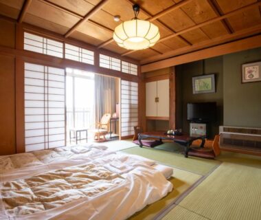 Traditional tatami room with futon, shoji screens, low table and wooden ceiling at Shimaya in Nagano, Chūbu region