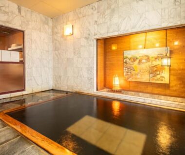 Wood-framed indoor bath with marble walls and warm lighting at Shimaya, Nagano, Chūbu