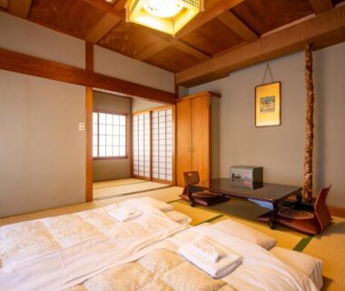 Traditional tatami room with futons, low table and shoji screens at Shimaya in Nagano