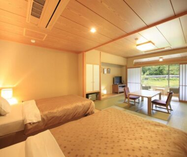 Spacious tatami room with twin beds, low table and sliding shoji doors at Shimoda Central Hotel, Shizuoka, Chūbu, Japan