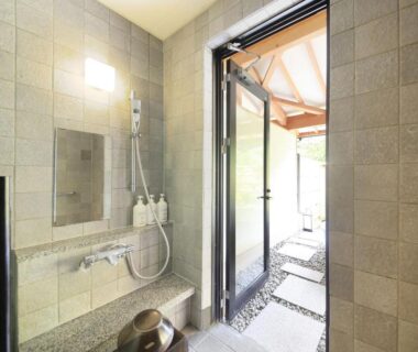 Shower area with bench and wooden bucket leading to garden path at Shimoda Central Hotel Shizuoka