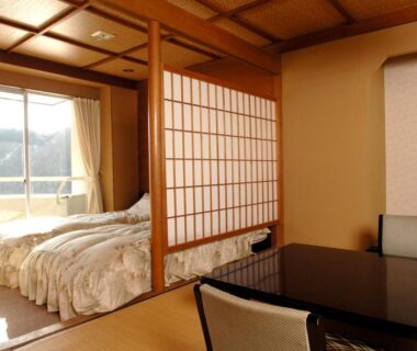 Tatami flooring and low table beside Western beds at Shimoda Kaihin Hotel in Shizuoka, Chūbu, Japan