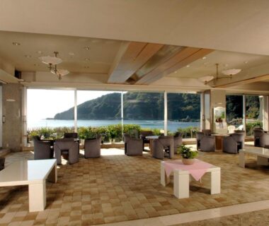 Bright lounge with low tables and seating facing coastal view at Shimoda Kaihin Hotel, Shizuoka, Chūbu, Japan