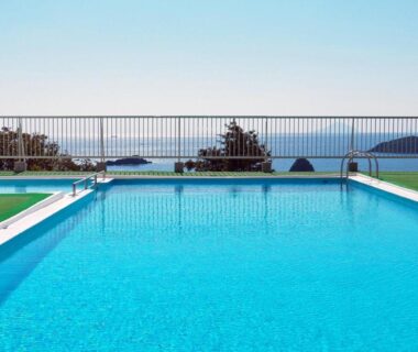 Outdoor pool with railing and distant sea horizon at Shimoda View Hotel in Shizuoka