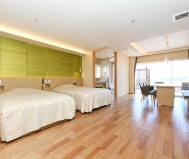 Bright twin room with hardwood floors, two beds, seating area by window and sliding wooden screens at Shimoda Yamatokan Shizuoka