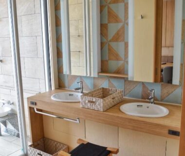Double basins and wooden vanity with geometric tiles, sliding glass door at Shimoda Yamatokan Shizuoka