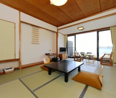 Traditional tatami room with low table, floor cushions, sliding doors and balcony seating at Shimoda Yamatokan Shizuoka