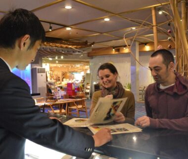 Couple reviewing brochures with receptionist at Shimoda Yamatokan reception in Shizuoka