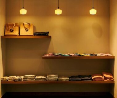 Folded yukata on wooden shelves at Shin Kaikatei Izumi in Shizuoka