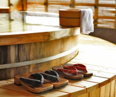 Circular wooden onsen bath with wooden sandals and towel at Shin Kaikatei Izumi in Shizuoka Chūbu Japan