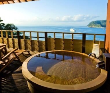 Round wooden outdoor onsen bath on terrace at Shin Kaikatei Izumi with coastal view, Shizuoka, Chūbu, Japan