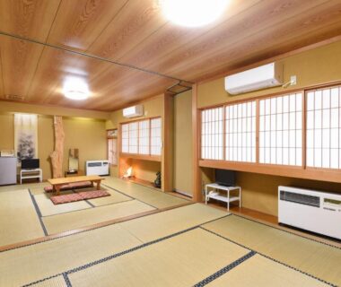Spacious tatami room with low table, seating cushions, shoji screens and traditional alcove at Shinseikan, Iwate