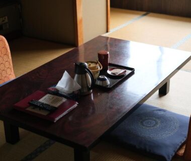 Low wooden table on tatami with cushions, kettle and cups at Shinwaka Lodge in Wakayama