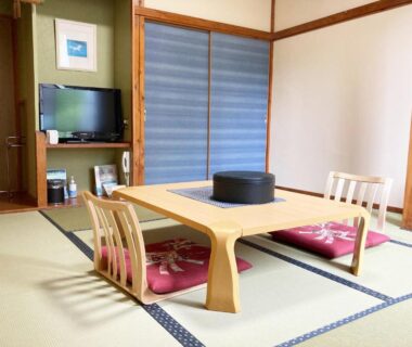 Traditional tatami room with low wooden table, floor cushions and shoji screens at Shinyu Onsen Kurikomaso, Miyagi