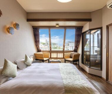 Western-style room with twin beds and seating area by large window in Shizuoka
