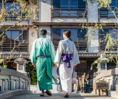 Two guests in yukata walking toward traditional ryokan entrance at Shinzan Kinosaki in Hyōgo