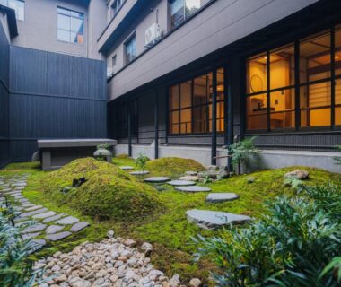 Tranquil moss courtyard with stepping stones beside Shinzan Kinosaki shoji windows in Hyōgo