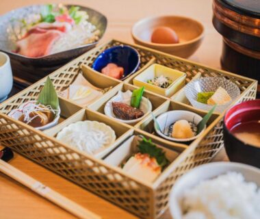 Compartmented wooden box with assorted small dishes, rice bowl, soup bowl and chopsticks at Shinzan Kinosaki