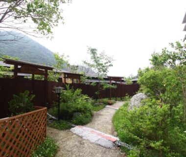 Winding garden path by wooden fence at Shiobara Onsen Hotel Ohruri in Tochigi