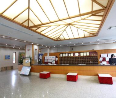 Spacious reception area with wooden check-in counter and red seating at Shiobara Onsen Hotel Ohruri, Tochigi, Japan