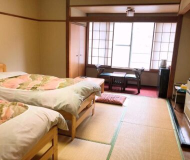 Japanese tatami room with two beds, shoji screens and low table at Shiobara Onsen Hotel Ohruri, Tochigi