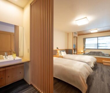 Twin beds with wooden divider and vanity at ShirabuOnsen Higashiya in Yamagata