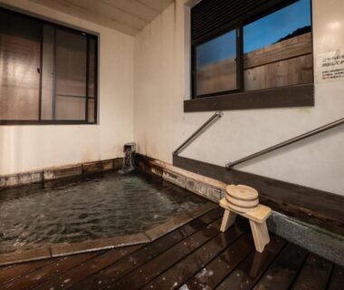 Indoor wooden bath with ladle, stool and windows at ShirabuOnsen Higashiya, Yamagata