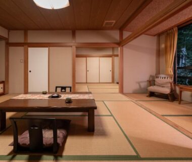 Traditional tatami room with low table, zabuton cushions and shoji screens at ShirabuOnsen Higashiya Yamagata