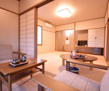 Tatami room with round low table, shoji screens and seating at Shirahama no Yado Daigo in Wakayama