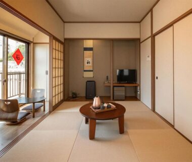 Traditional tatami room with low round table, kettle and shoji doors opening to balcony at Shirahama no Yado Daigo, Wakayama