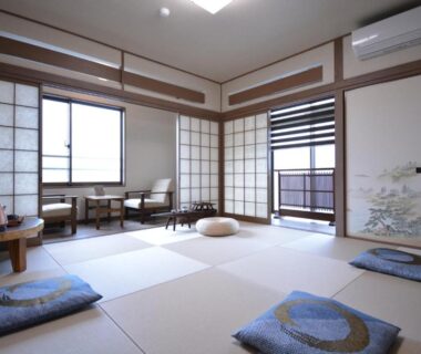 Spacious tatami room with zabuton cushions, low table and shoji screens at a Wakayama ryokan