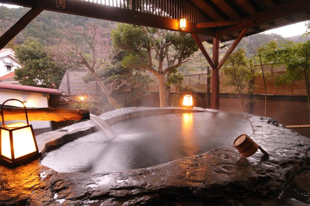 Stone onsen pavilion at Shirakabe Shizuoka Steaming stone onsen with lanterns and wooden roof at Shirakabe, Shizuoka