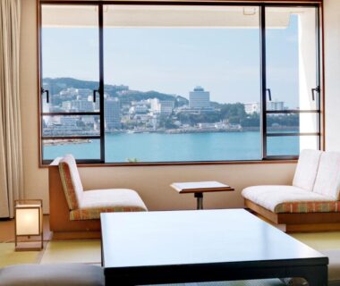 Tatami seating area facing bay through large window at Shiraraso Grand Hotel in Wakayama