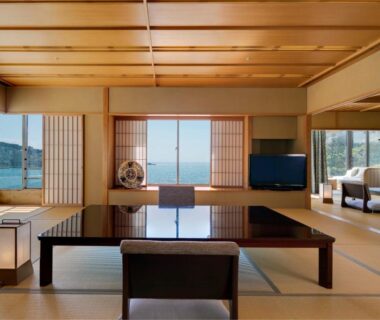 Traditional tatami room with low table, shoji screens and large windows overlooking coastal waters at Shiraraso Grand Hotel, Wakayama